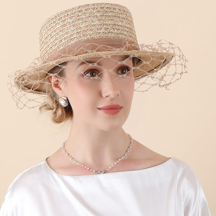 Model wearing beige coffee tone raffia hat with veil outdoors