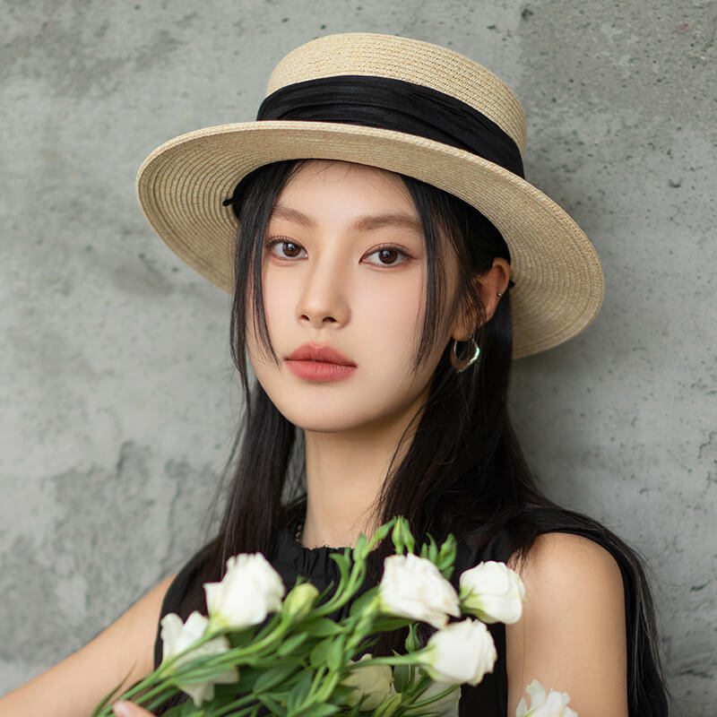 Woman in black dress styled with black organza boater hat – chic summer look