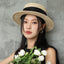 Woman in black dress styled with black organza boater hat – chic summer look