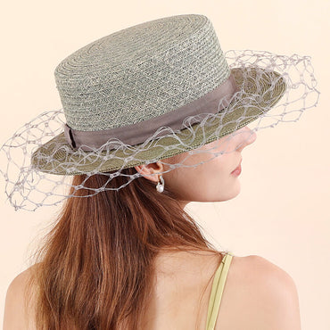 Model styling light avocado raffia hat with veil in summer outfit